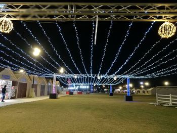 Low angle view of illuminated lights hanging from ceiling at night