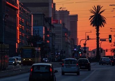 Cars on road in city during sunset