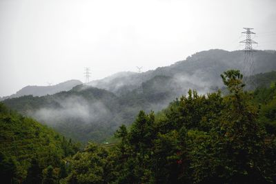 Scenic view of tree mountains against sky during foggy weather