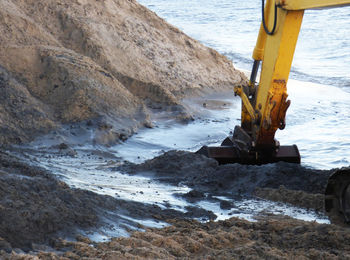 Cropped image of earth mover at beach