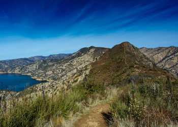 Scenic view of mountains against blue sky