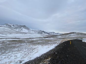 Scenic view of snowcapped mountains by sea against sky