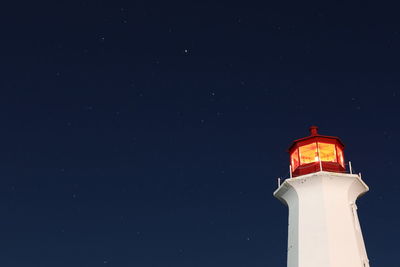 Low angle view of lighthouse against sky at night