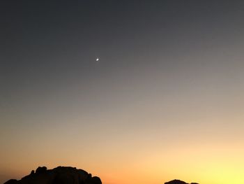 Low angle view of silhouette moon against sky at sunset