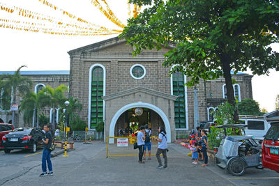 People on street against buildings in city