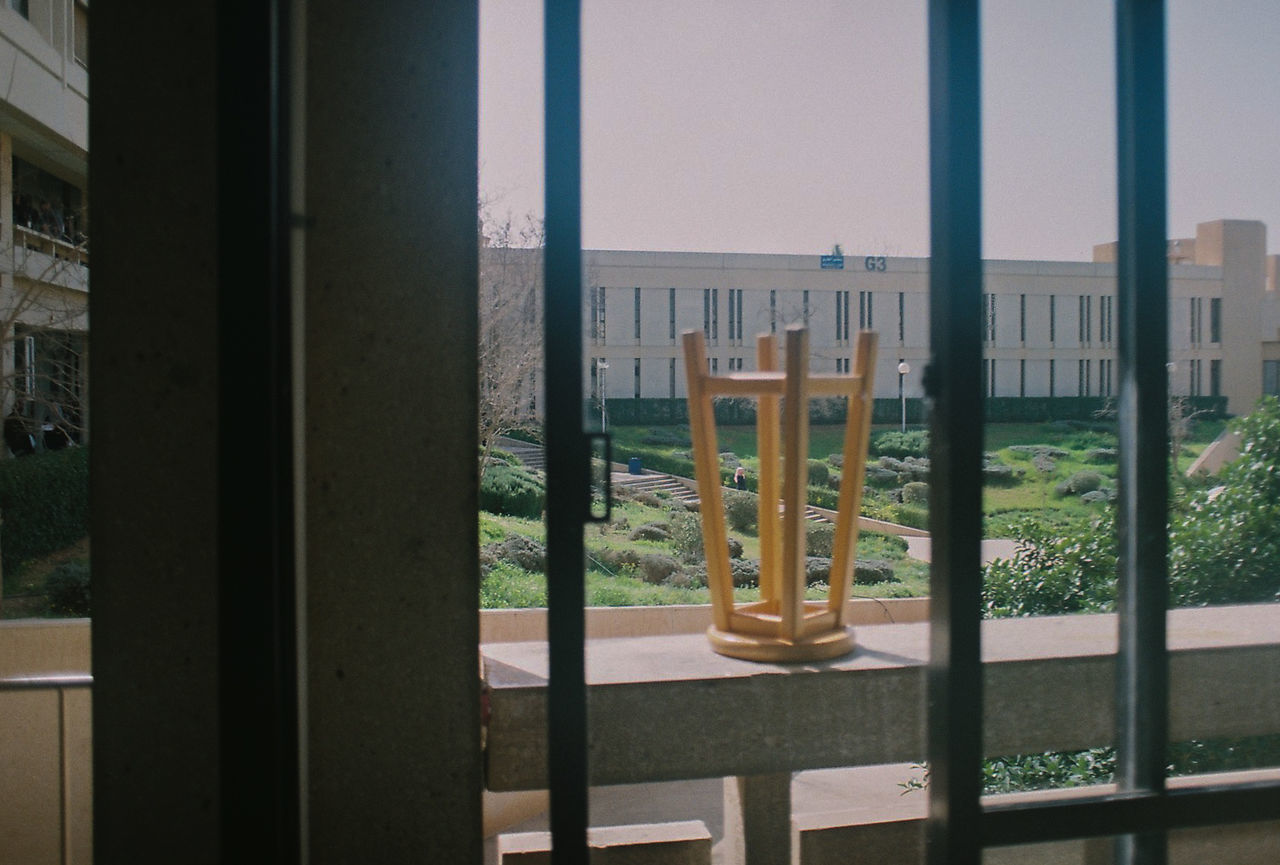 CLOSE-UP OF BUILDINGS AGAINST CLEAR SKY SEEN THROUGH WINDOW