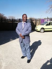 Full length portrait of young man standing on sunny day