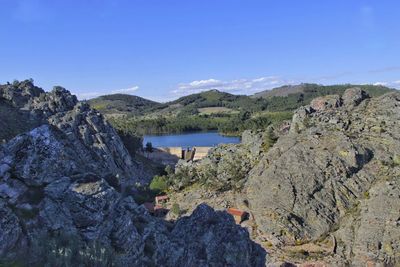 Scenic view of rocky mountains against blue sky