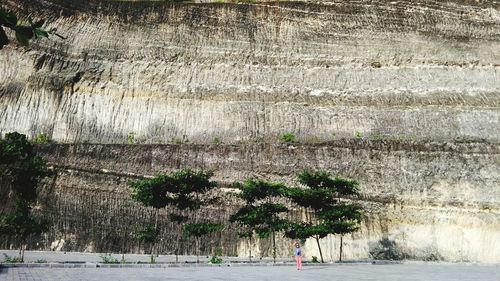 Woman standing against rock formation