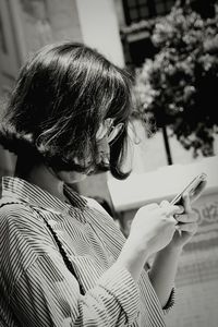 Tilt shot of woman using mobile phone on sunny day