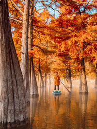 Rear view of woman standing in lake