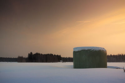 Snow covered field at sunset