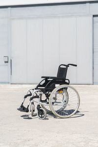 Empty wheelchair at military base on sunny day