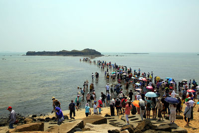 People on beach against clear sky