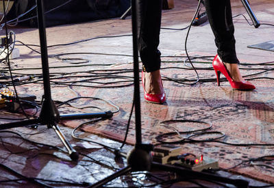 Low section of woman standing amidst wires on stage