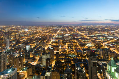 High angle view of city lit up at night