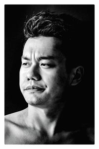 Close-up portrait of young man against black background