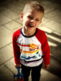 High angle view of smiling boy standing on floor