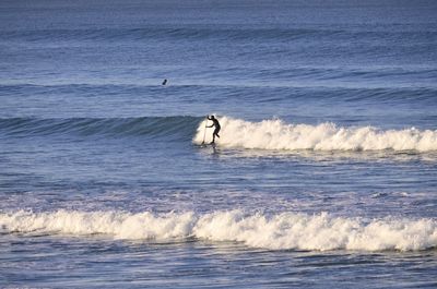 Man surfing on wave in sea