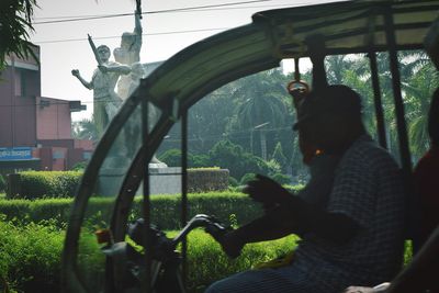 Man sitting by statue