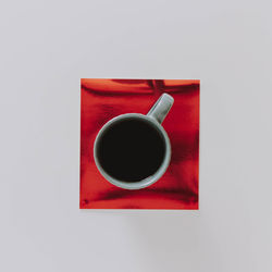 Directly above shot of black coffee cup on table against white background