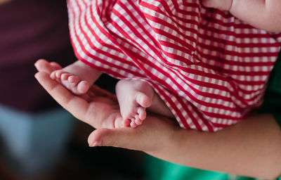 Midsection of couple holding baby feet