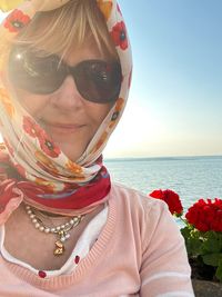 Portrait of woman wearing sunglasses against sea