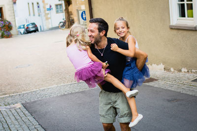 Happy father with daughters on road