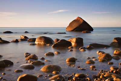 Surface level view of calm pebble beach at sunrise