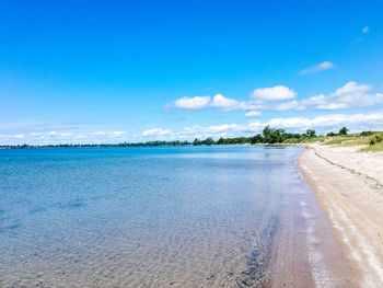 Scenic view of beach against blue sky