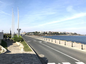 Road by sea against sky in city