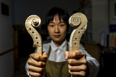 Young chinese violin maker at work in her workshop