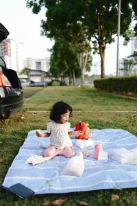 Front view of girl sitting on grass picnic