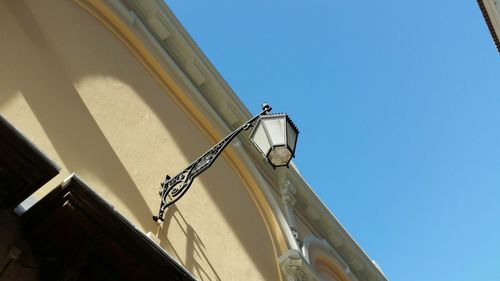 Low angle view of chandelier against clear blue sky