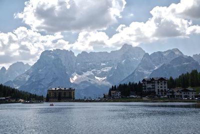 Scenic view of lake by buildings against sky