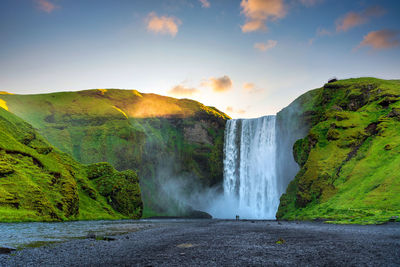 Scenic view of waterfall against sky