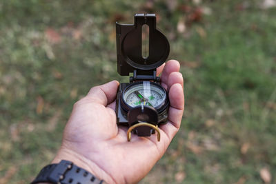 Cropped image of hand holding navigational compass