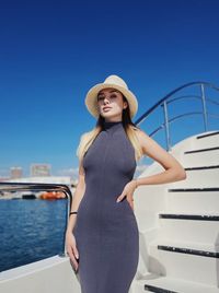 Portrait of young woman standing against sea