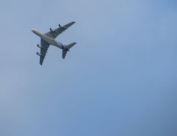 Low angle view of airplane flying against clear sky