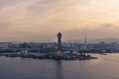 View of buildings at waterfront against cloudy sky