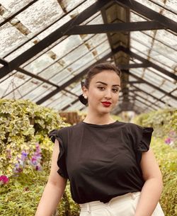 Portrait of young woman standing against plants