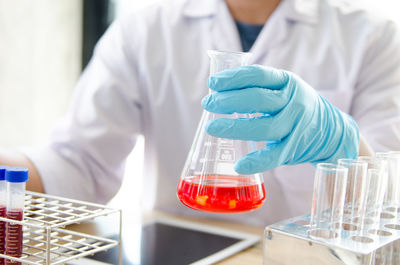 Midsection of male scientist experimenting in laboratory