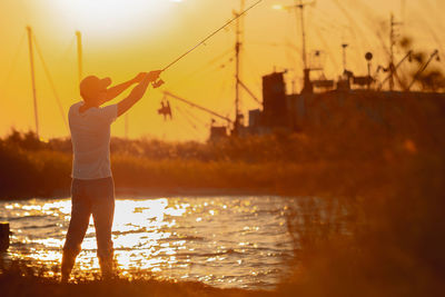 Low angle view of silhouette woman standing in water