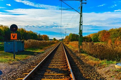 Railroad tracks by trees against sky