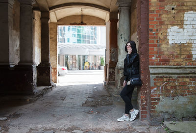 Full length of woman standing against building