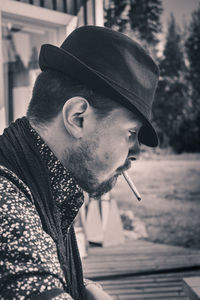 Close-up of young man smoking while sitting outdoors