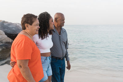 Senior couple with their granddaughter walking at the beach together