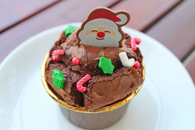 Closeup of chocolate cupcake topped with santa choco and christmas sprinkles