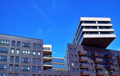 Low angle view of buildings against clear blue sky