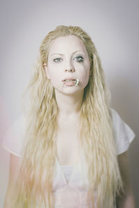 Portrait of young woman against white background